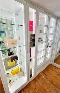 Custom closet with glass shelving and integrated lighting for modern storage