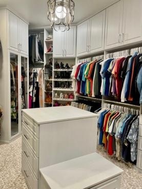 PRIMARY CLOSET WITH CLOTHES.jpg