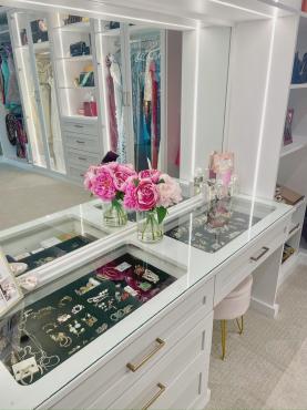 Walk-in closet featuring built-in seating area with surrounding custom storage