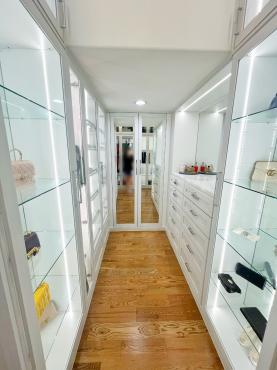 Spacious walk-in closet with full-length mirrors and custom shelving units